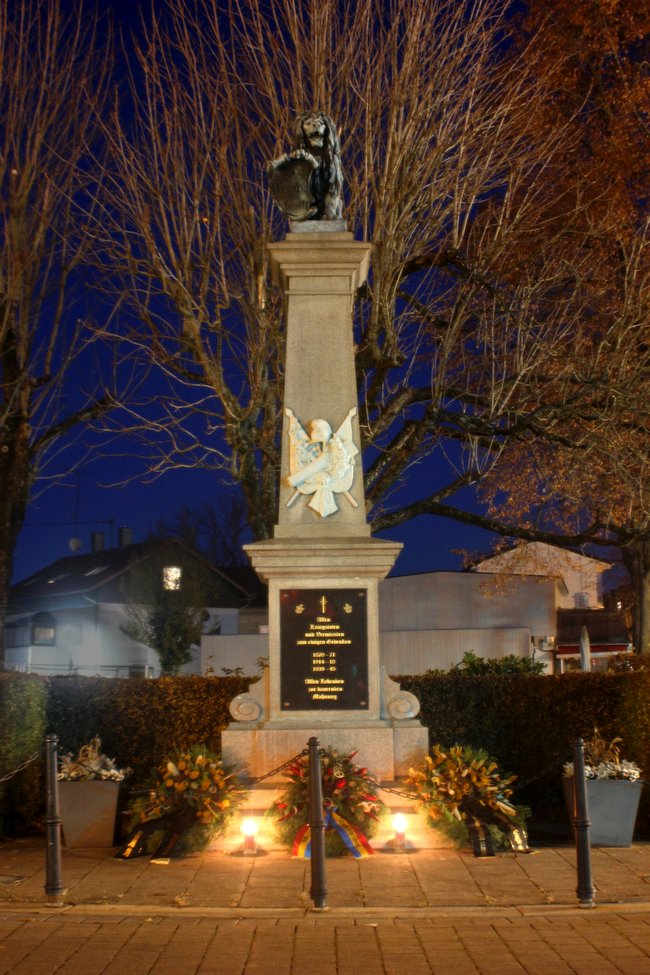 Bild: Kriegerdenkmal am Abend mit Kränzen und Kerzen